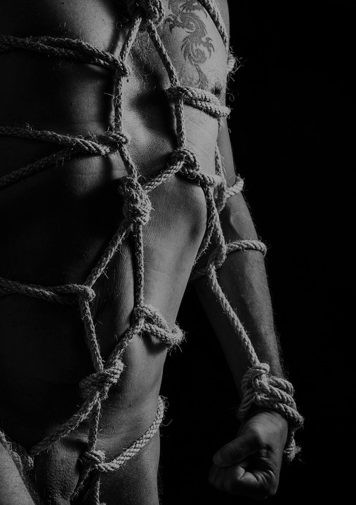 Naken man bunden med rep